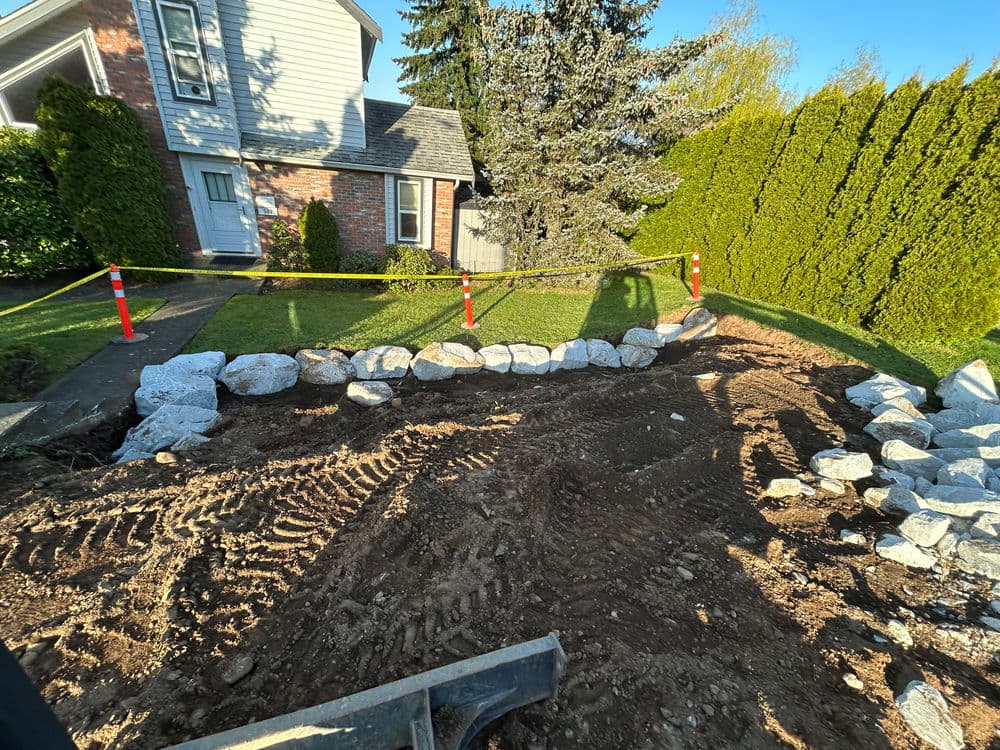Landscaping project with gravel and stone edging at a home, surrounded by caution tape.