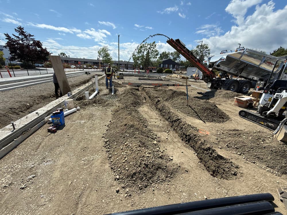 Construction site showing trench work and machinery for a new foundation installation.